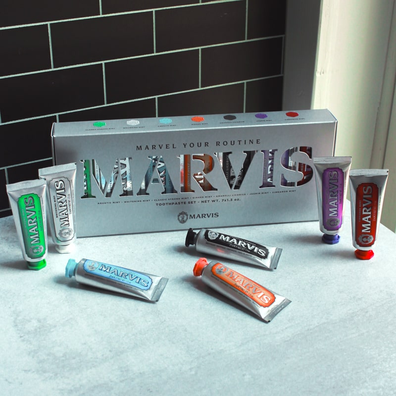 Lifestyle shot of Marvis Flavor Collection Gift Set box and tubes - Includes 25 ml each of: Amarelli Licorice, Aquatic Mint, Cinnamon Mint, Classic Strong Mint, Ginger Mint, Jasmine Mint and Whitening Mint shown with box