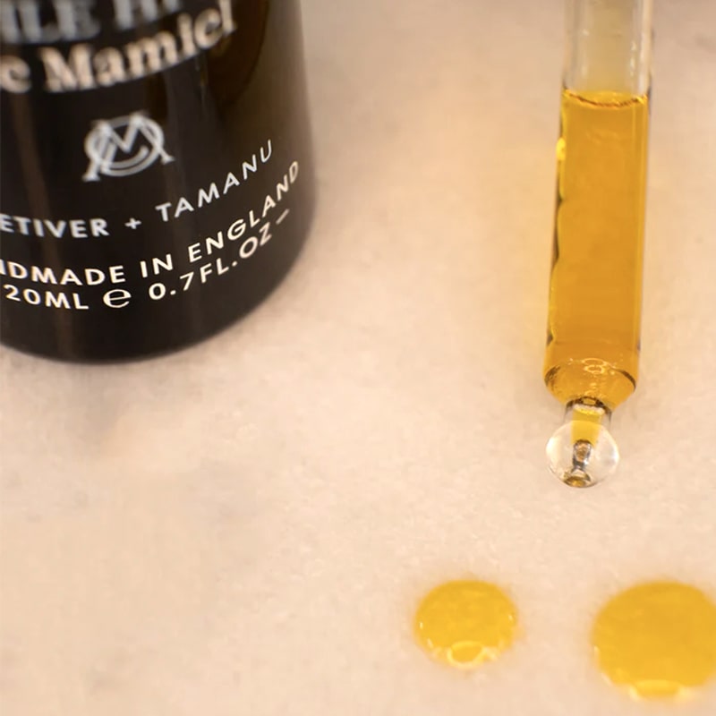 Close up shot of de Mamiel Winter Facial Oil dropper and oil drops