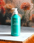 lifestyle shot of Kerzon Liquid Body Soap - Feuille d'Eucalyptus (16.67 oz) with flowers in the background