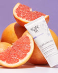 Lifestyle shot of Yon-Ka Paris Pamplemousse Creme PNG for Normal to Oily Skin (50 ml) with whole and sliced grapefruit in the background