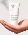 Close up of model holding Yon-Ka Paris Pamplemousse Creme PNG for Normal to Oily Skin (50 ml) in palm of hand