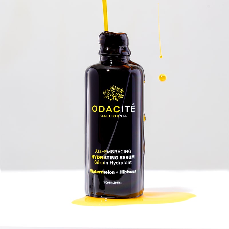 Odacite All-Embracing Hydrating Serum - product shown with serum dripping on bottle