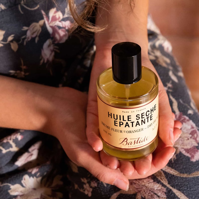 Model holding bottle of Bastide Huile D&#39;Aix Orange Blossom Bath Oil (250 ml)