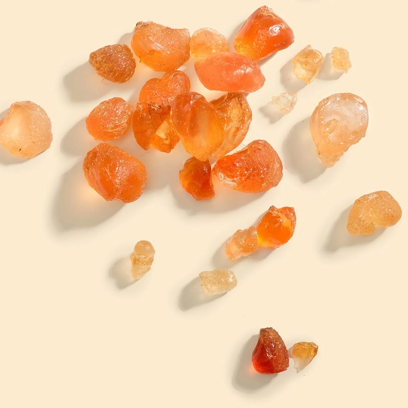 Top view of Bastide Ambre d&#39;Or Potpourri Crystals shown scattered about with varying sizes and colors.