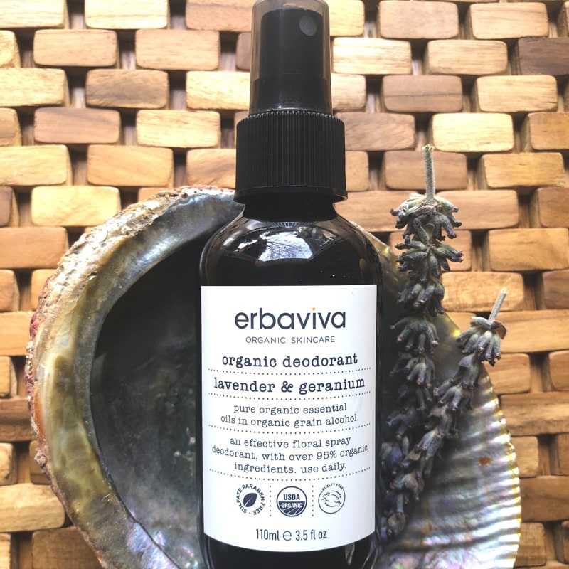 Lifestyle shot of Erbaviva Lavender & Geranium Organic Deodorant (3.5 oz) sitting in shell with lavender and wood tile background