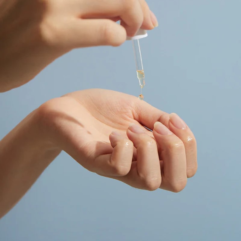 Close up of model applying JINsoon HyperCare Ex-Tract Honeysuckle + Primrose Cuticle Oil from dropper on to nails