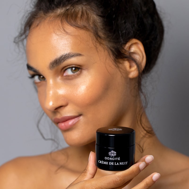 Model holding Odacite Creme de la Nuit (50 ml) close to her face