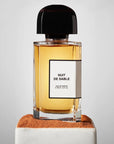 BDK Parfums Nuit de Sable Eau de Parfum (100 ml) beauty shot with bottle on pedestal with sand
