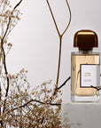 BDK Parfums Crème de Cuir Eau de Parfum (100 ml) bottle on pedestal with dried flowers and branches in the background