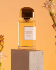BDK Parfums Tubereuse Imperiale Eau de Parfum (100 ml) beauty shot with bottle on pedestal and tubereuse flowers in the background
