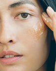 Close up of model applying Activist Manuka Honey Mask to cheek