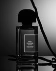 Lifestyle mood shot of BDK Parfums Gris Charnel Extrait (100 ml) bottle with vanilla bean pods in the background