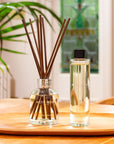 Lifestyle shot of Molton Brown Orange & Bergamot Aroma Reeds Diffuser (150 ml) shown next to bottle of refill (150 ml)