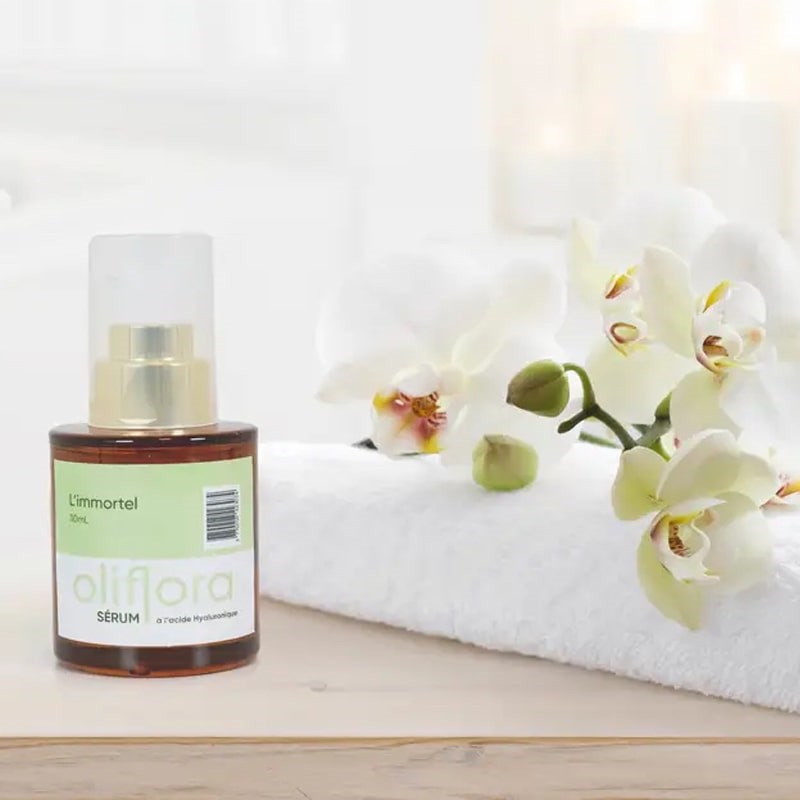 Oliflora L'immortel Hyaluronic Acid Serum - product shown next to towel and flowers