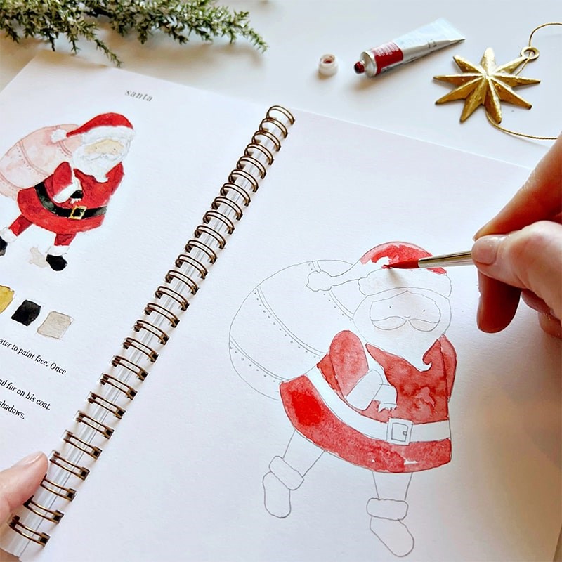 Emily Lex Studio Christmas Watercolor Workbook - model shown painting inside product