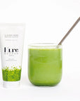 Kure Bazaar Matcha Shea Super Cream - hand cream tube next to glass of matcha with straw