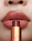 Augustinus Bader The Tinted Lip Balm - Shade 3 - model holding product next to lips