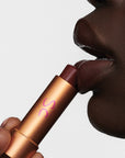 Augustinus Bader The Tinted Lip Balm - Shade 3 - model holding product touching lips