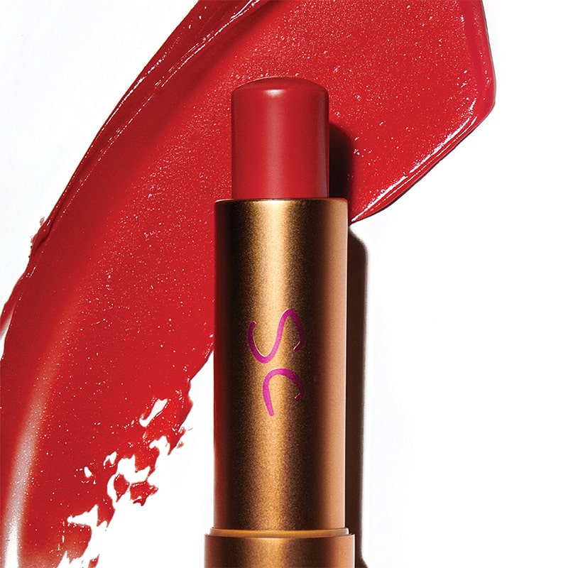 Augustinus Bader The Tinted Lip Balm - Shade 2 - product shown in front of texture color swatch