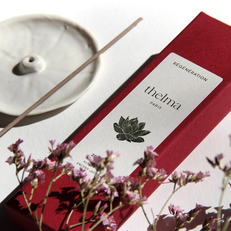 Thelma Paris Regeneration Incense Sticks - product packaging shown next to incense stick, incense holder, and cherry blossoms