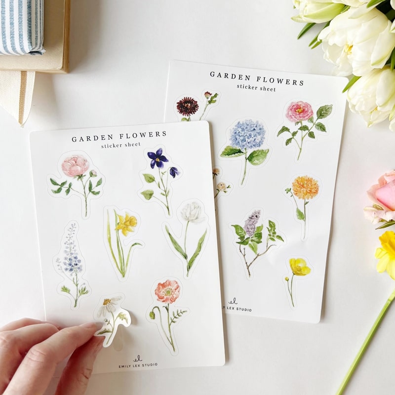 Emily Lex Studio Garden Flowers Sticker Sheet - models hand removing sticker from sheet next to flowers