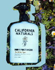 California Naturals Body Moisturizer - product shown in front of flowers and graphic blue background