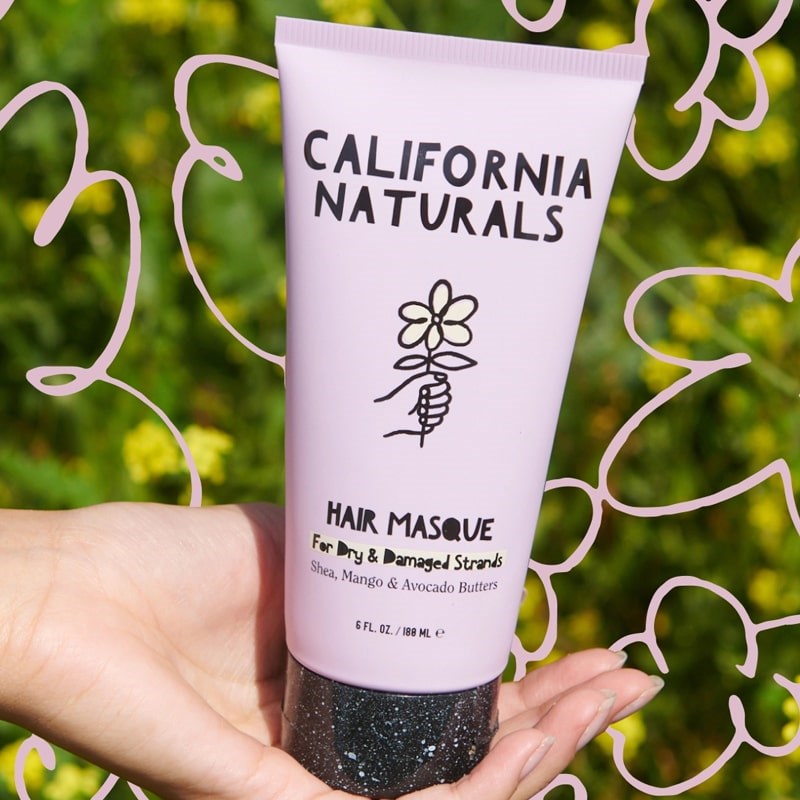 California Naturals Hair Masque - model holding product in front of flowers