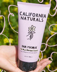 California Naturals Hair Masque - model holding product in front of flowers