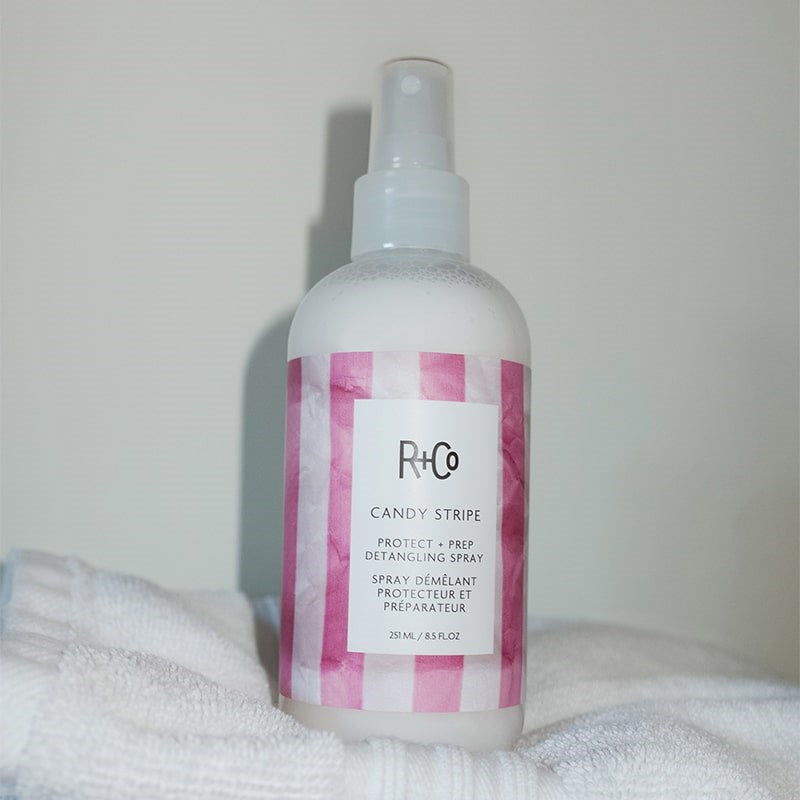 R+Co Candy Stripe Protect + Prep Detangling Spray - product shown on towels