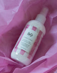 R+Co Candy Stripe Protect + Prep Detangling Spray - product shown in pink tissue paper