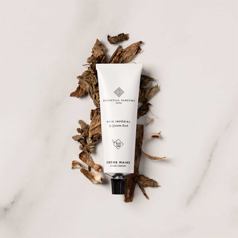 Essential Parfums Hand Cream - Bois Imperial - product on top of fragrance ingredients