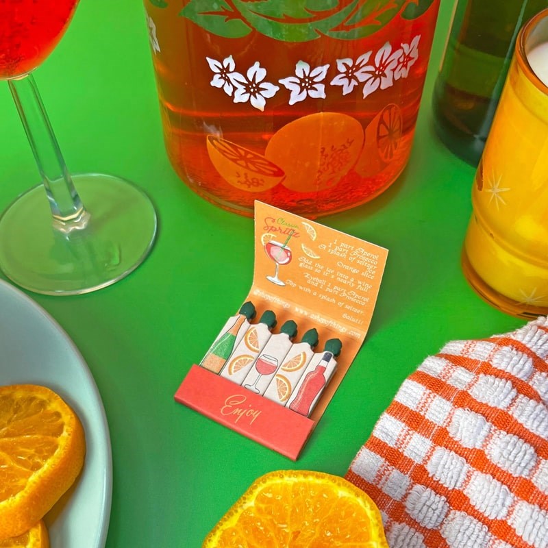 A Shop of Things Spritz Matches - open matchbook shown next to oranges and glasses