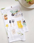 Emily Lex Studio Gardening Tea Towel - product shown folded on table next to dish