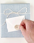 Emily Lex Studio Paint Palette Mini Notecard - model shown placing sticker on envelope on top of gift