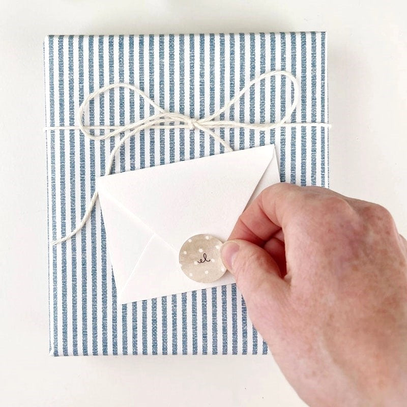 Emily Lex Studio Sweet Pea Mini Notecard - model placing sticker on envelope on top of gift