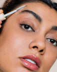 Close up of model applying Rye Beauty Brow Milk to eyebrown