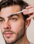 Close up of male model applying Lifestyle shot of Rye Beauty Brow Milk to eyebrow