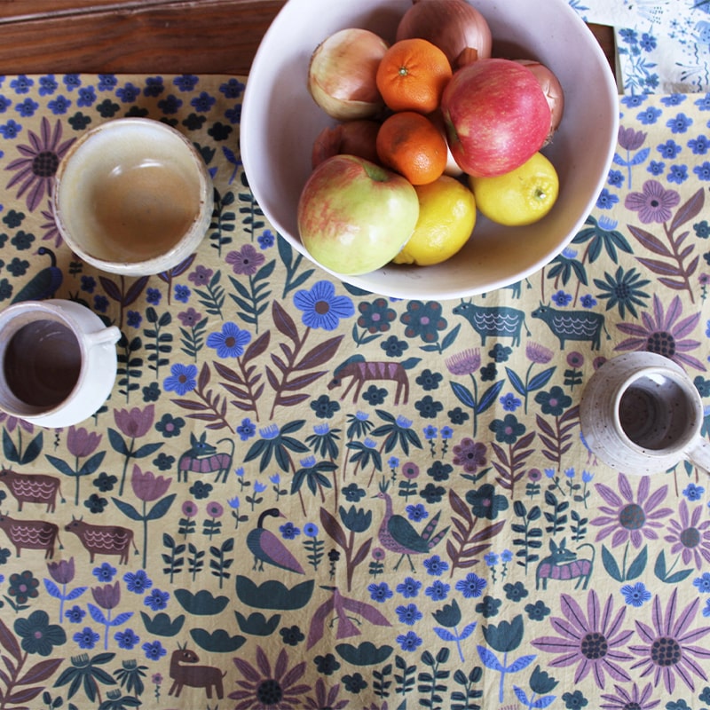 Leah Duncan Folklore Art Tea Towel - lifestyle photo of fruit bowl and cups on top of product