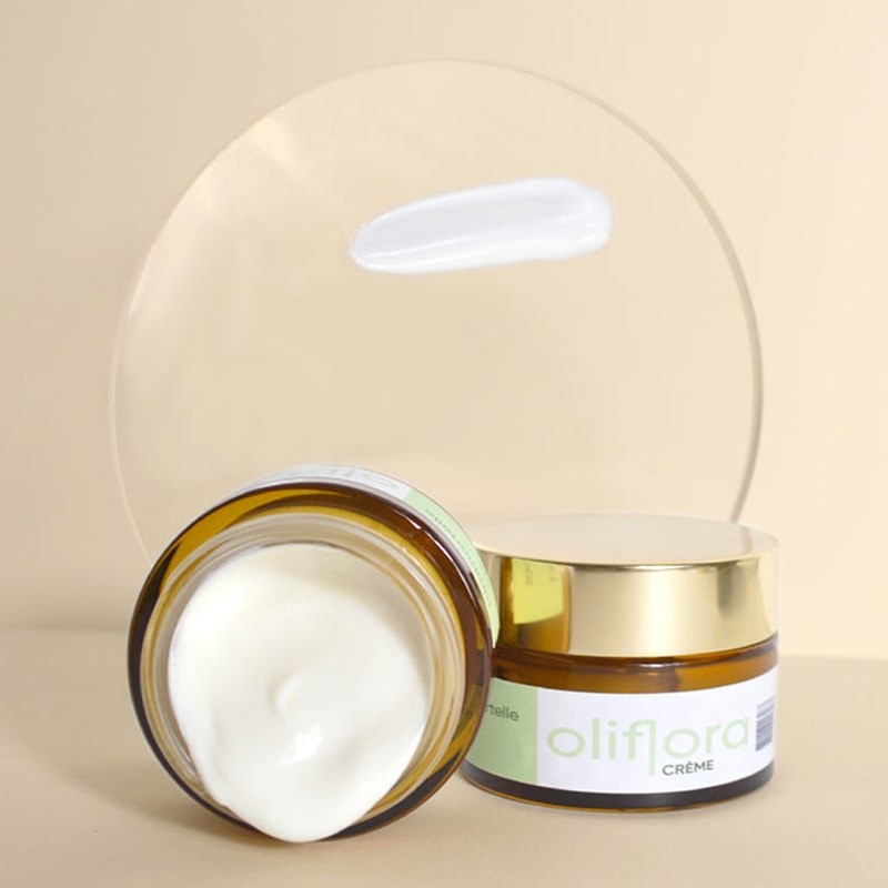 Oliflora L'immortelle Creme - product shown with open cap and closed cap with a texture swatch on glass plate