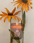 The Quiet Botanist Orchard Sun Scented Candle - product shown with flowers