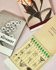 The Quiet Botanist Forever Flowers Scented Candle - product matchbooks opened and closed shown