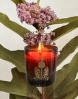 The Quiet Botanist Forever Flowers Scented Candle - Lit candle shown in front of flower