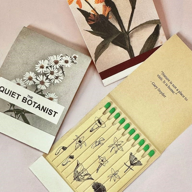 The Quiet Botanist In The Weeds Scented Candle - product matchbooks opened and closed shown