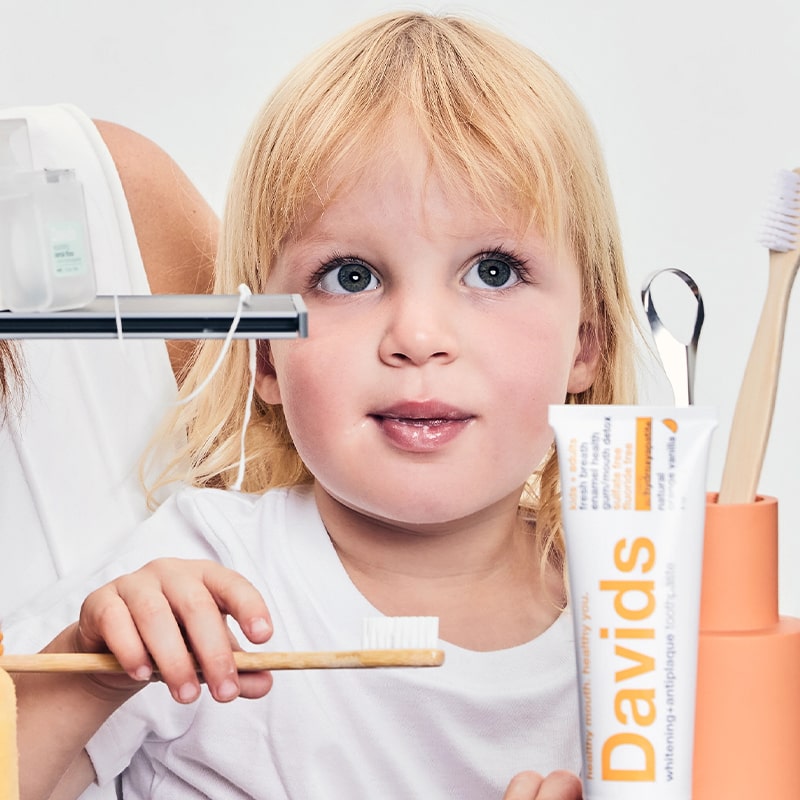 Davids Premium Toothpaste - Kids + Adults Nano-Hydroxyapatite Orange Vanilla - model using product with toothbrush