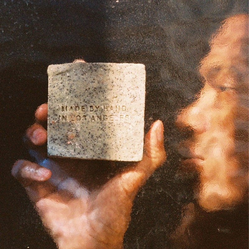 Flamingo Estate Organics Exfoliating Peppermint Soap Brick - model shown holding product behind glass