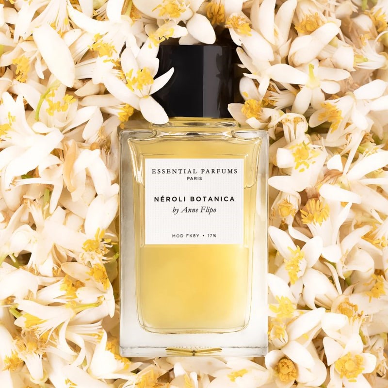 Lifestyle shot top view of Essential Parfums Neroli Botanica By Anne Flipo (100 ml) with Neroli flowers in the background