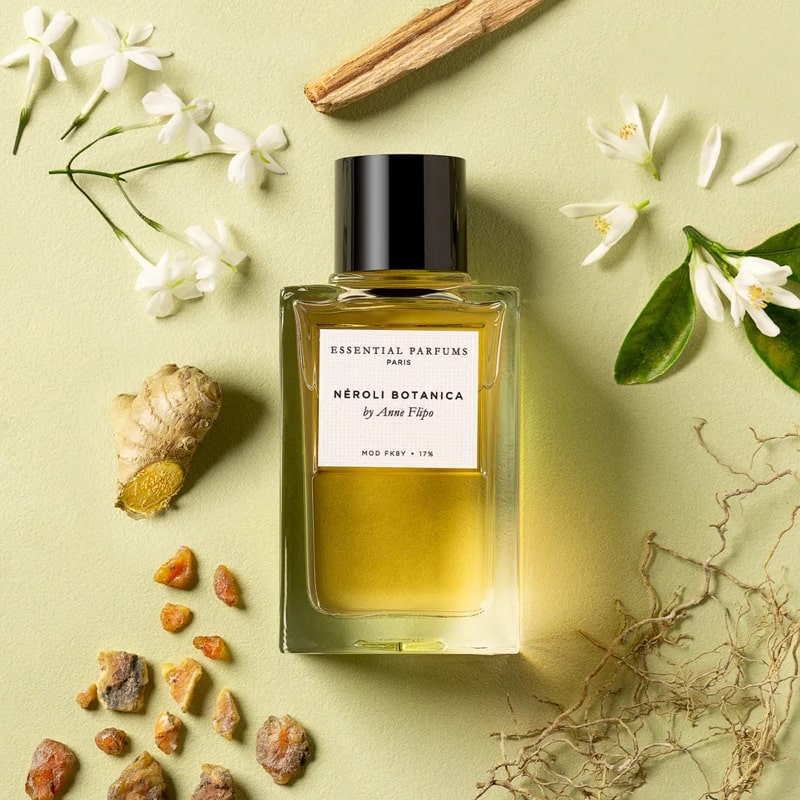 Lifestyle shot top view of Essential Parfums Neroli Botanica By Anne Flipo (100 ml) with neroli, ginger and other ingredients in the background