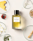 Lifestyle shot top view of Essential Parfums Neroli Botanica By Anne Flipo (100 ml) with neroli, ginger and other ingredients in the background