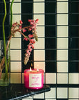 ROEN Candles De Las Flores Scented Candle - product shown on shelf next to vase with flowers