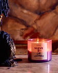 ROEN Candles Nueve Leones Scented Candle - product shown lit next to candle holder